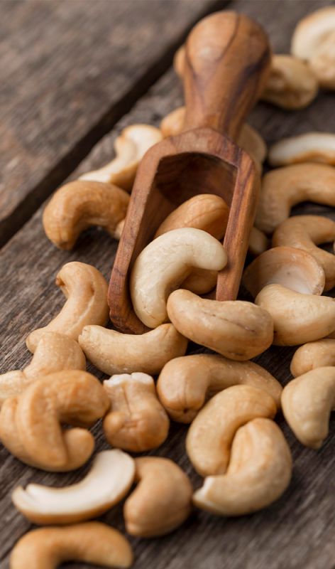 Hands holding raw cashew fruit